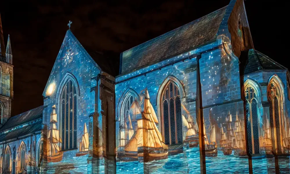 A church with a seascape projection mapped onto it's side.